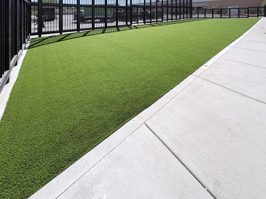 Black steel picket fence enclosing an artificial turf yard beside a concrete walkway, Brilliantmont, Las Vegas Valley NV
