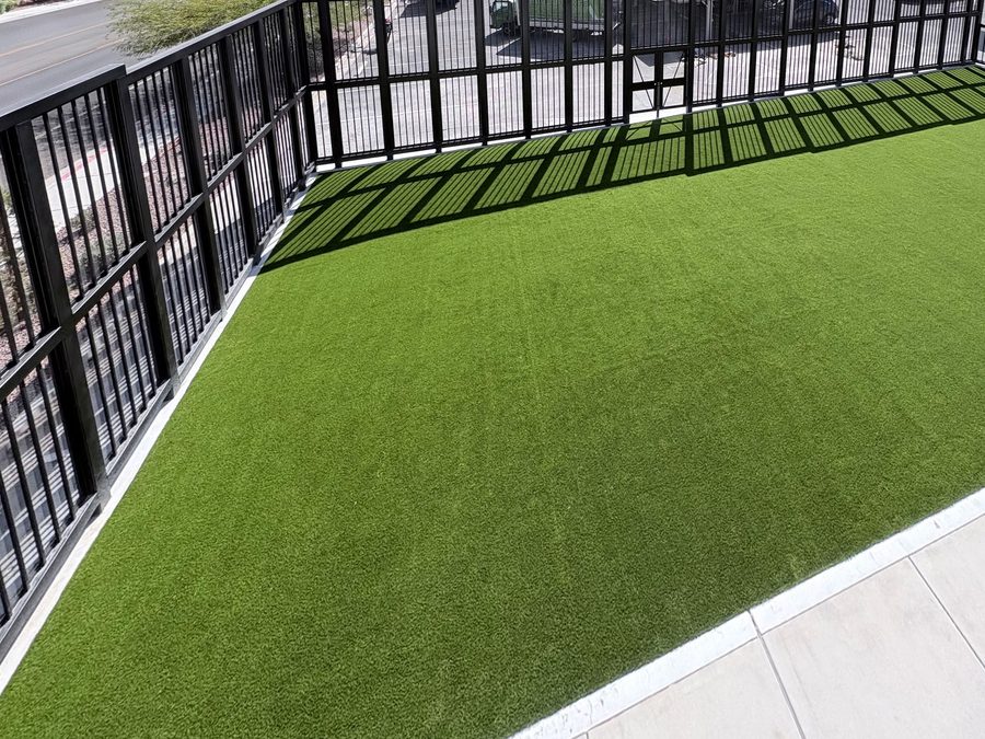 Elevated view of an artificial turf yard enclosed by black steel picket fencing with a concrete walkway, Brilliantmont, Las Vegas Valley NV
