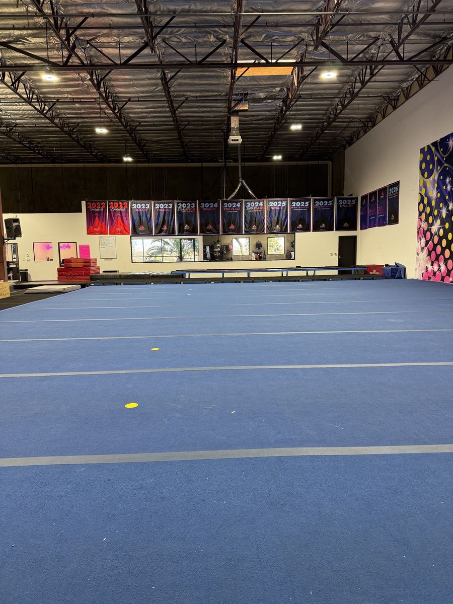 Blue spring floor across the open gym under LED high-bay lighting, CheerCats tenant improvement, Henderson NV