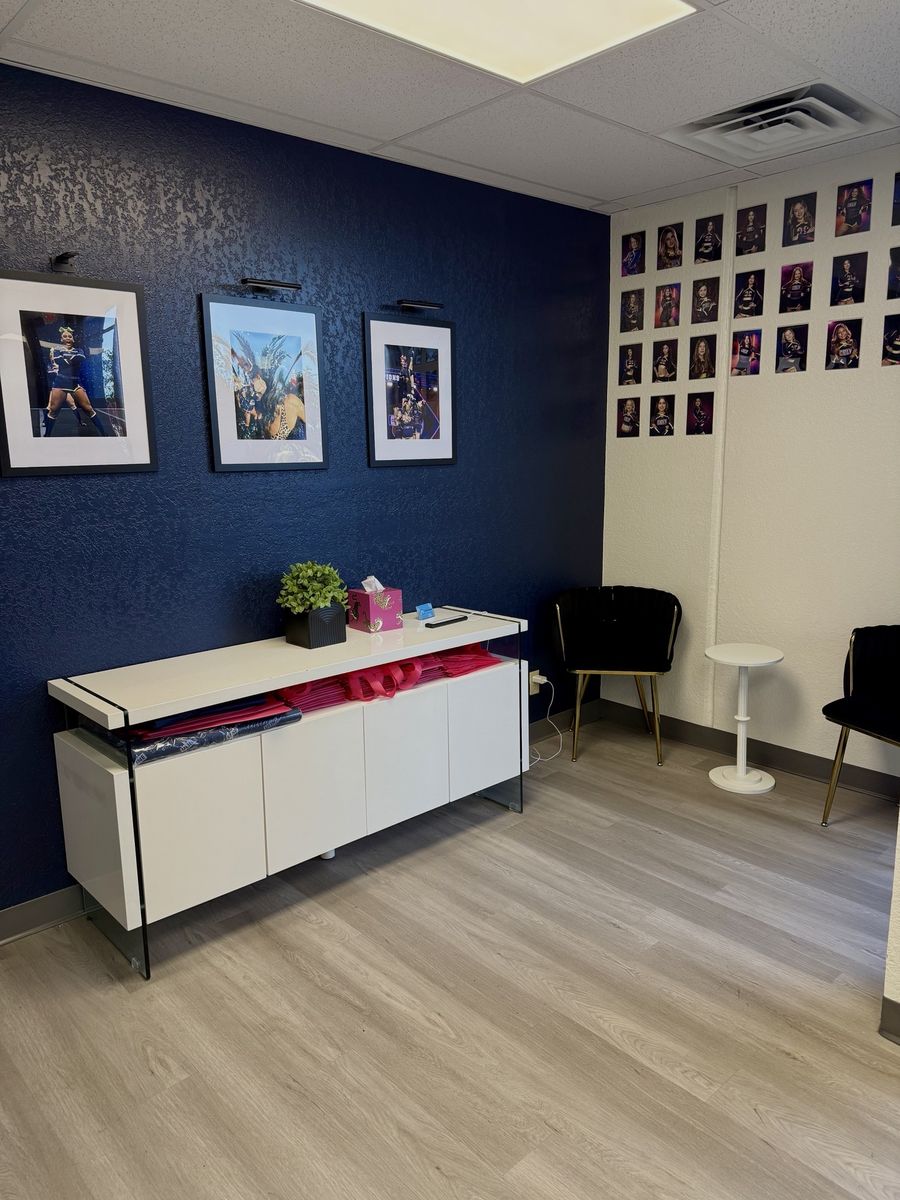 Navy accent wall with framed photos and white cabinet, CheerCats tenant improvement, Henderson NV