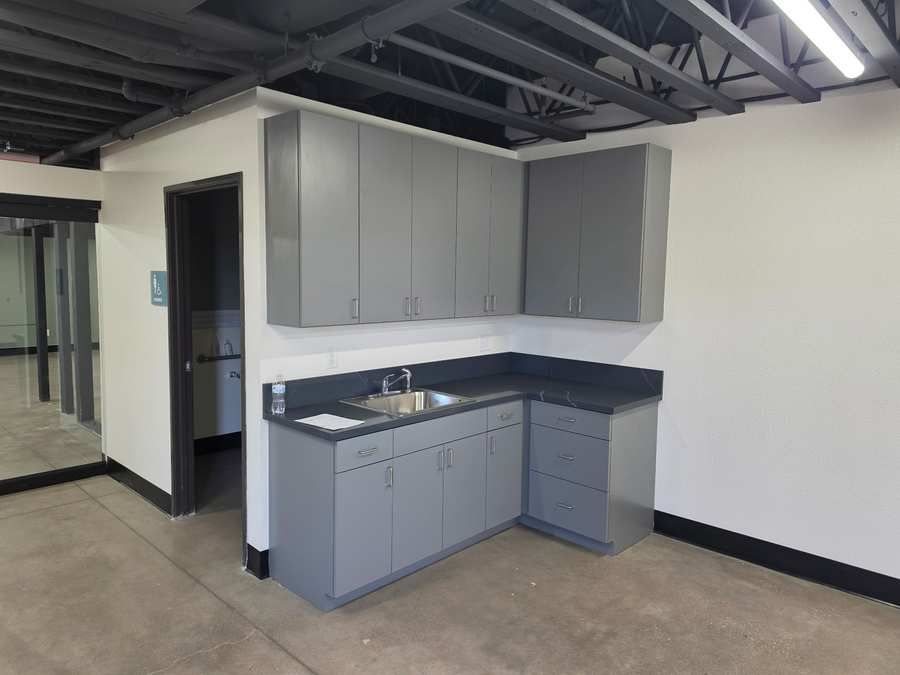 Breakroom with gray millwork cabinets and dark countertop and sink in a Las Vegas tenant improvement for Sustain Vegas